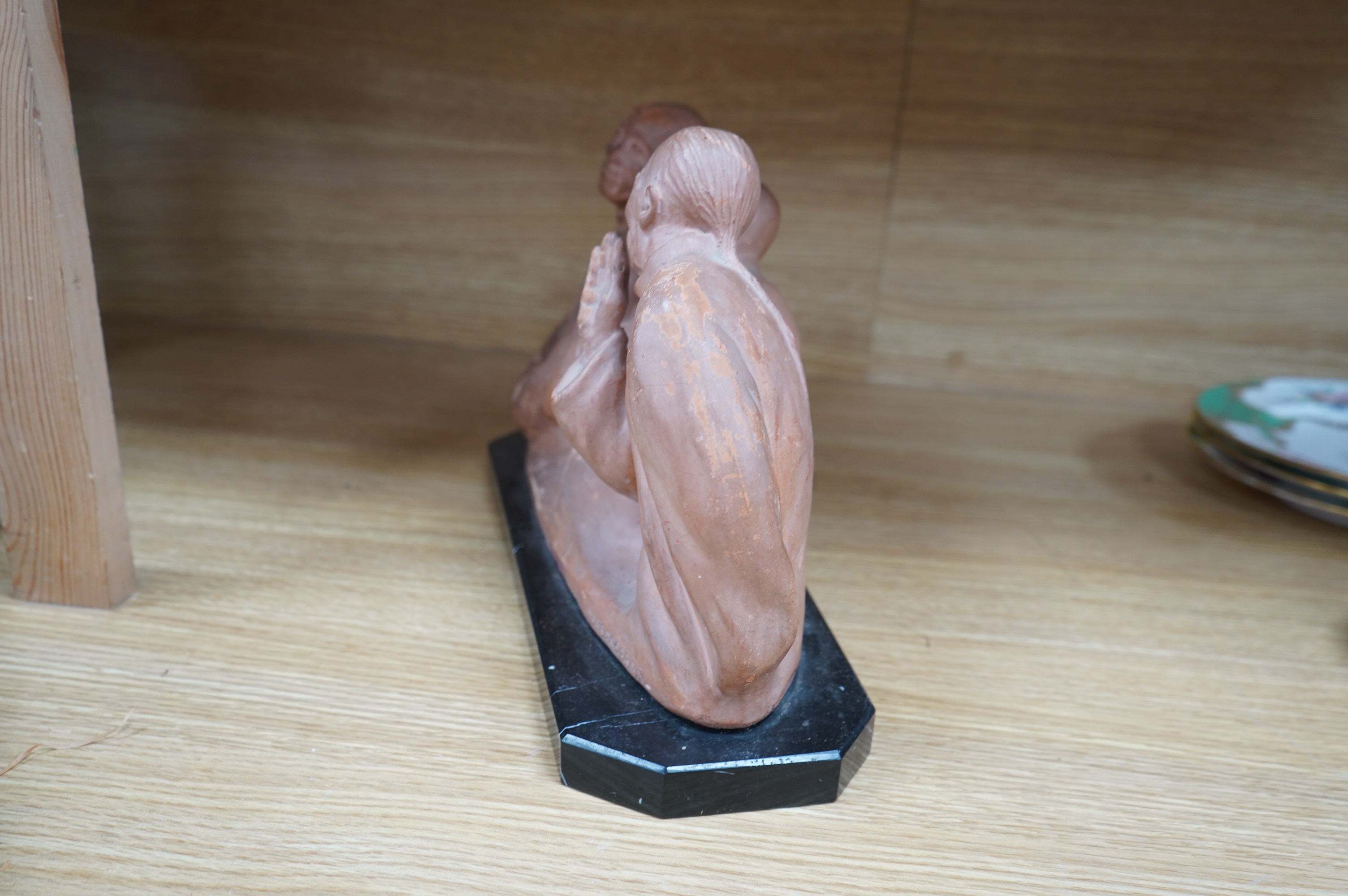 A French Art Deco terracotta sculpture of three seated Asian gentlemen, signature near base, 35cm high. Condition - fair